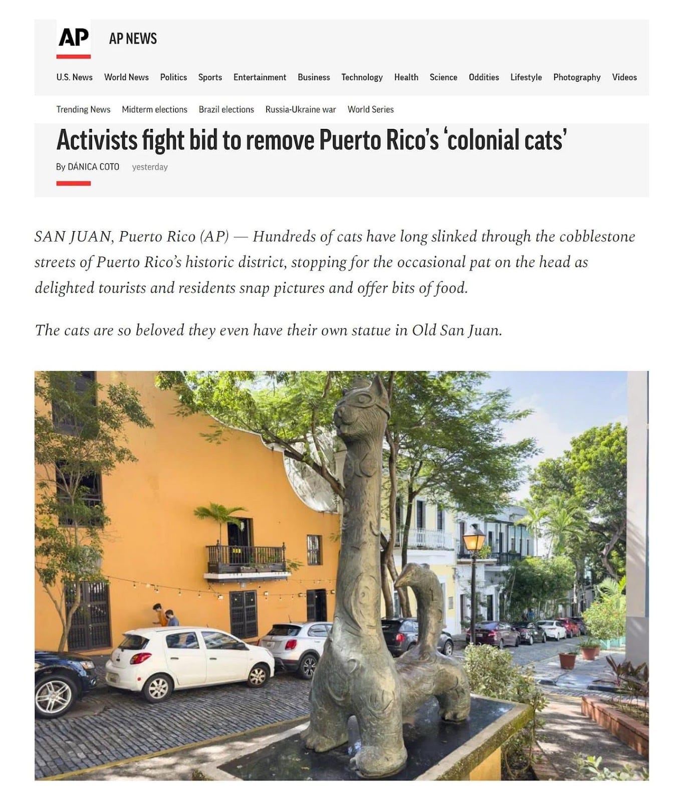 A statue of a cat on a street
Description automatically generated